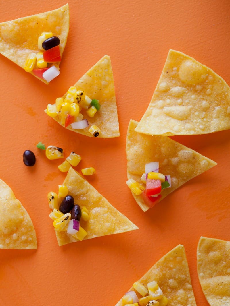 A close up of grilled corn salsa on tortilla chips.