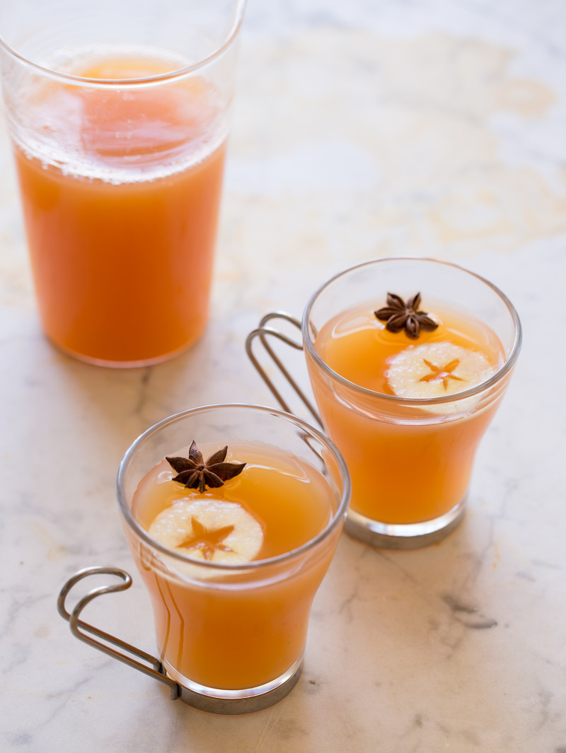 A couple glasses of honeycrisp and bourbon spiced cider with apple wheels and star anise.