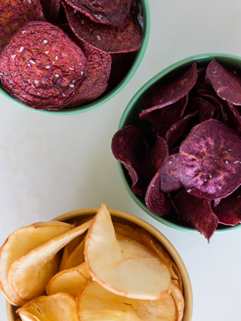 A close up of bowls of different types of root chips.