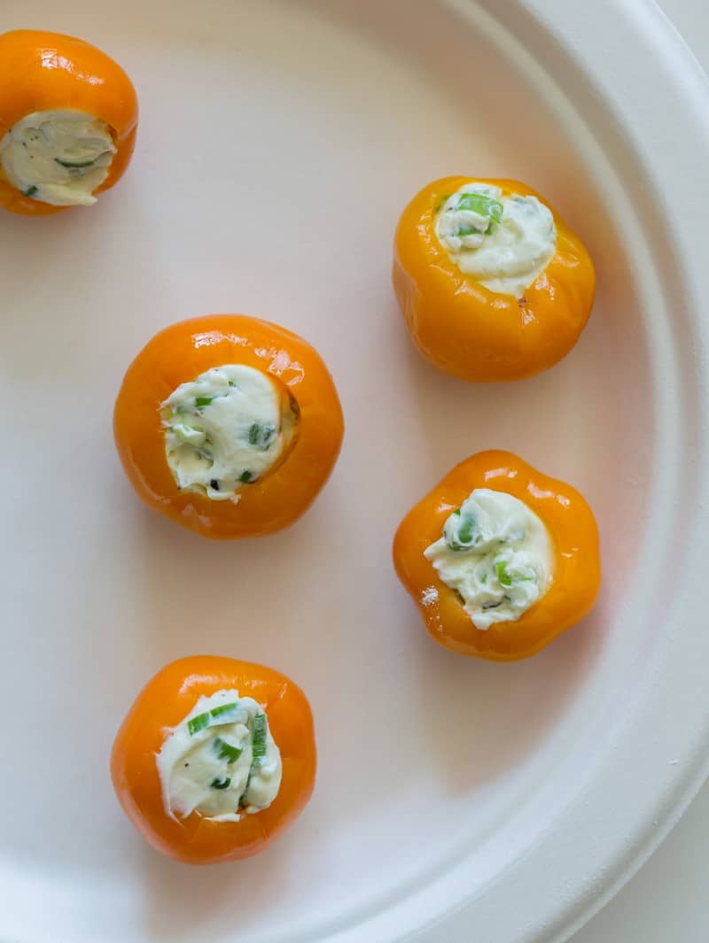 A plate of peppadew peppers full of cream cheese filling.