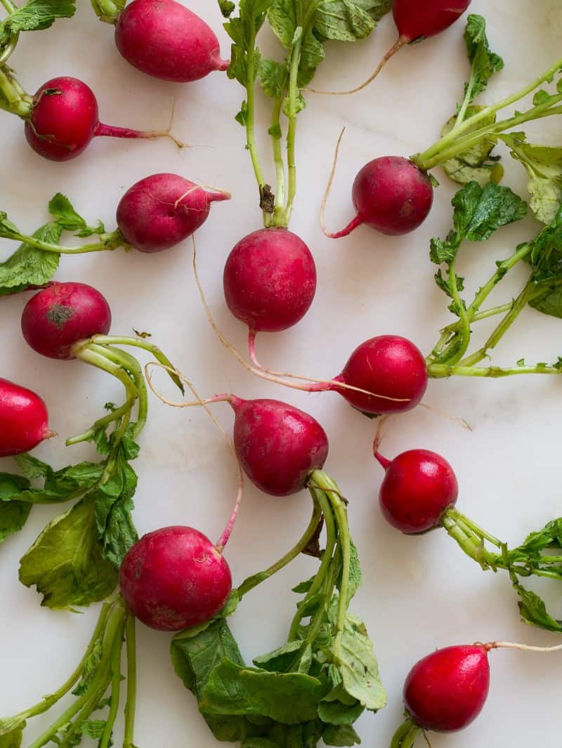 Fresh radishes with long stems still attached.