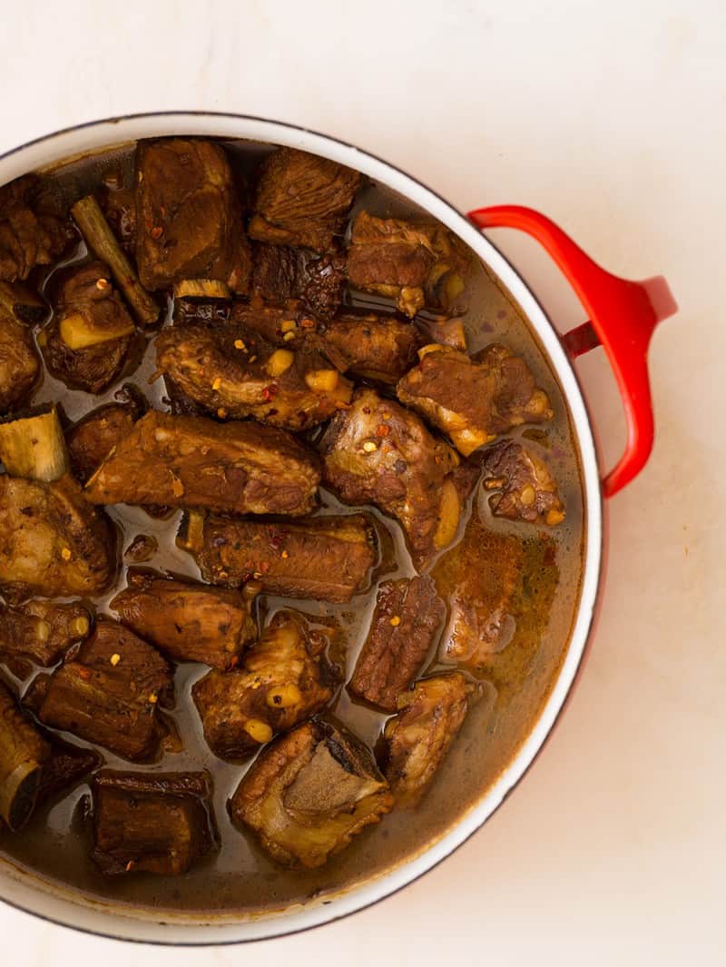 A large red pot of honey soy braised ribs.
