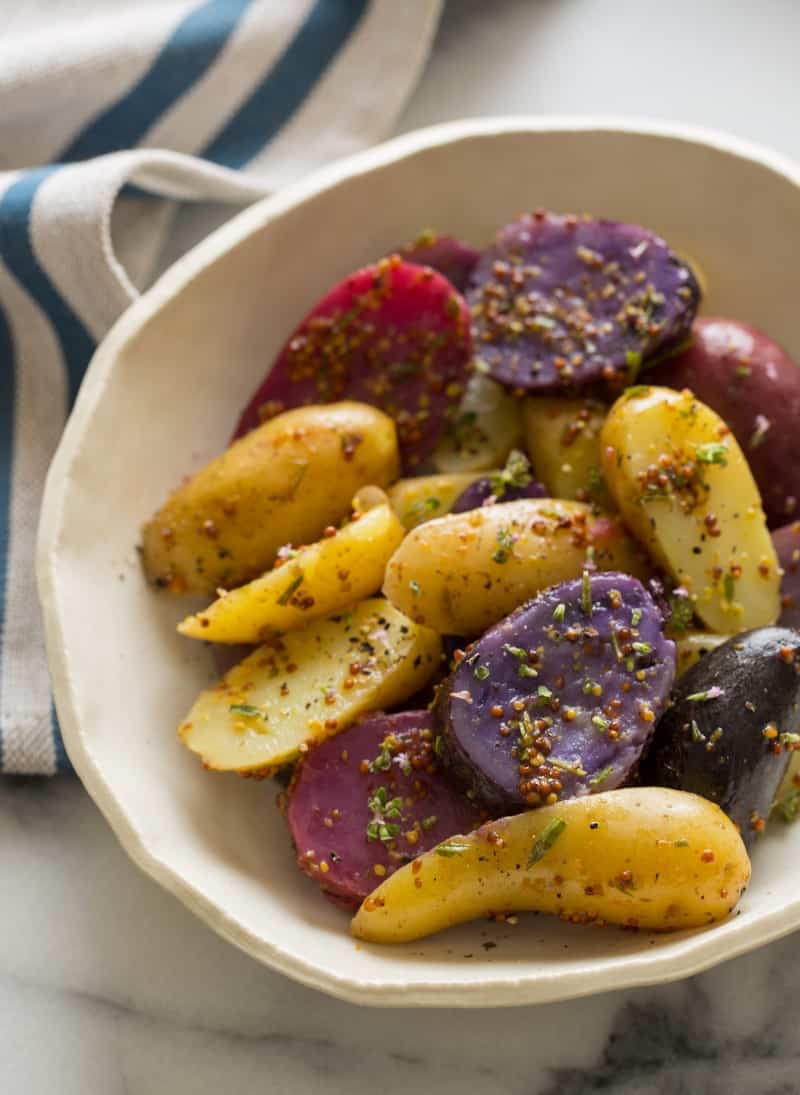 A close up of a bowl of warm German potato salad.