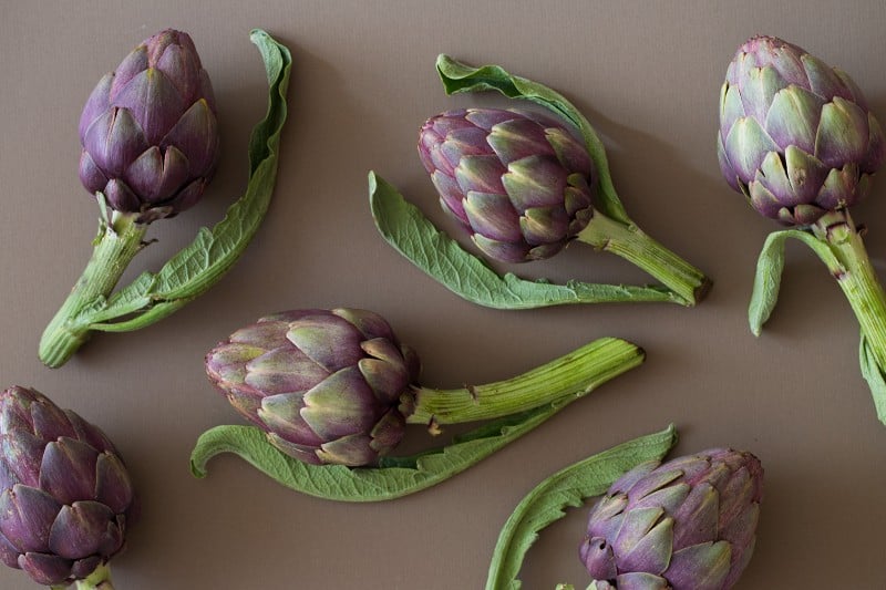 A close up of fresh raw artichokes.