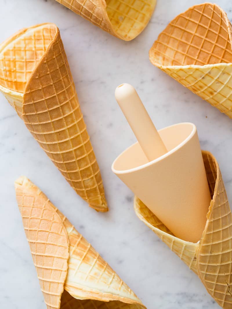 A close up of homemade waffle cones and a cone roller.