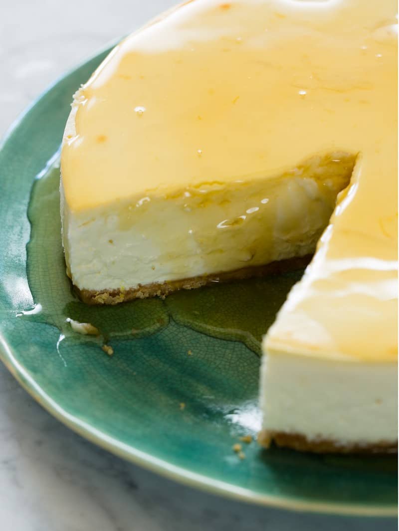 A close up of a sliced goat cheese and yogurt cheesecake drizzled with honey.