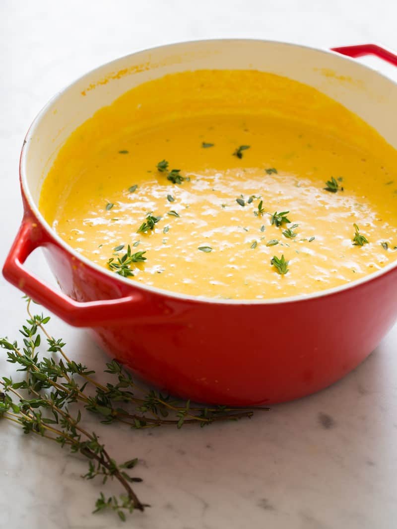 A pot of pumpkin beer cheese soup with thyme.