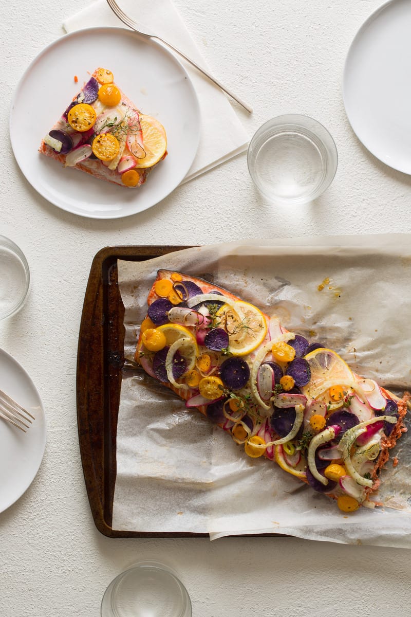 A side of stacked salmon and a piece served on a plate.