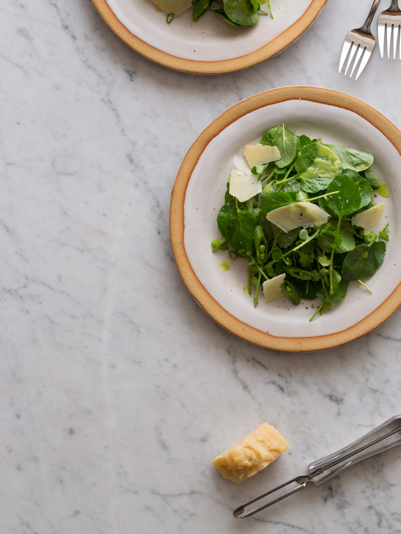 Watercress salad with green apple vinaigrette on a plate.