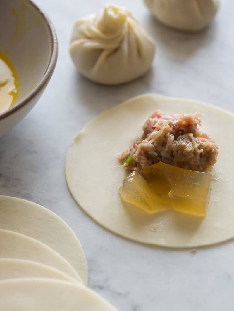 A close up of a wonton wrapper with filling, ready to be folded.