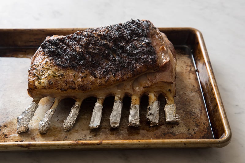 A finished grilled rack of lamb on a sheet pan.