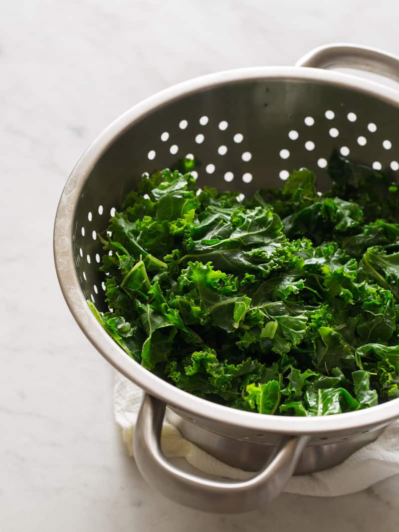 A close up of fresh kale, chopped and steamed in a colander.