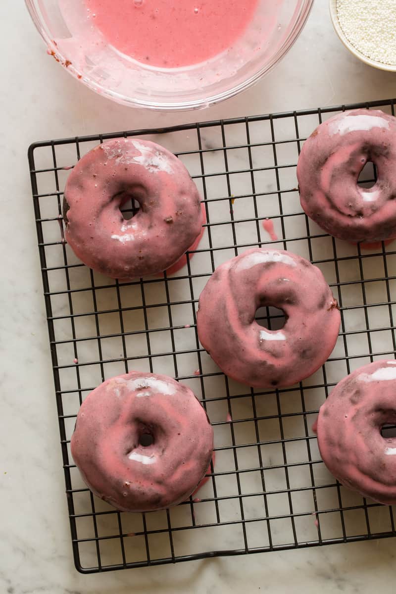 Chocolate and cardamom baked doughnut with sweet plum glaze on a wire rack.