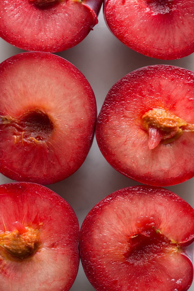 A close up of the flesh of halved fresh sweet plums.