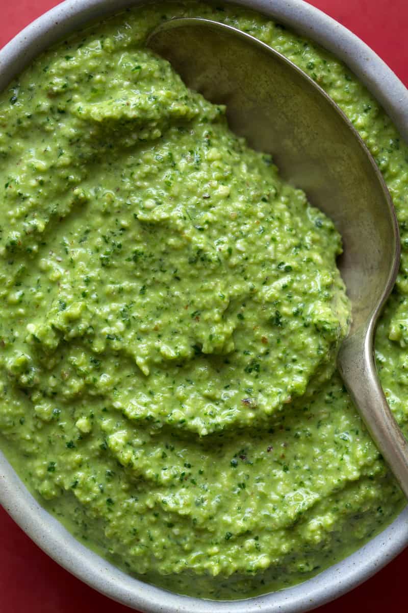 A close up of Tallarines verde sauce with a spoon.