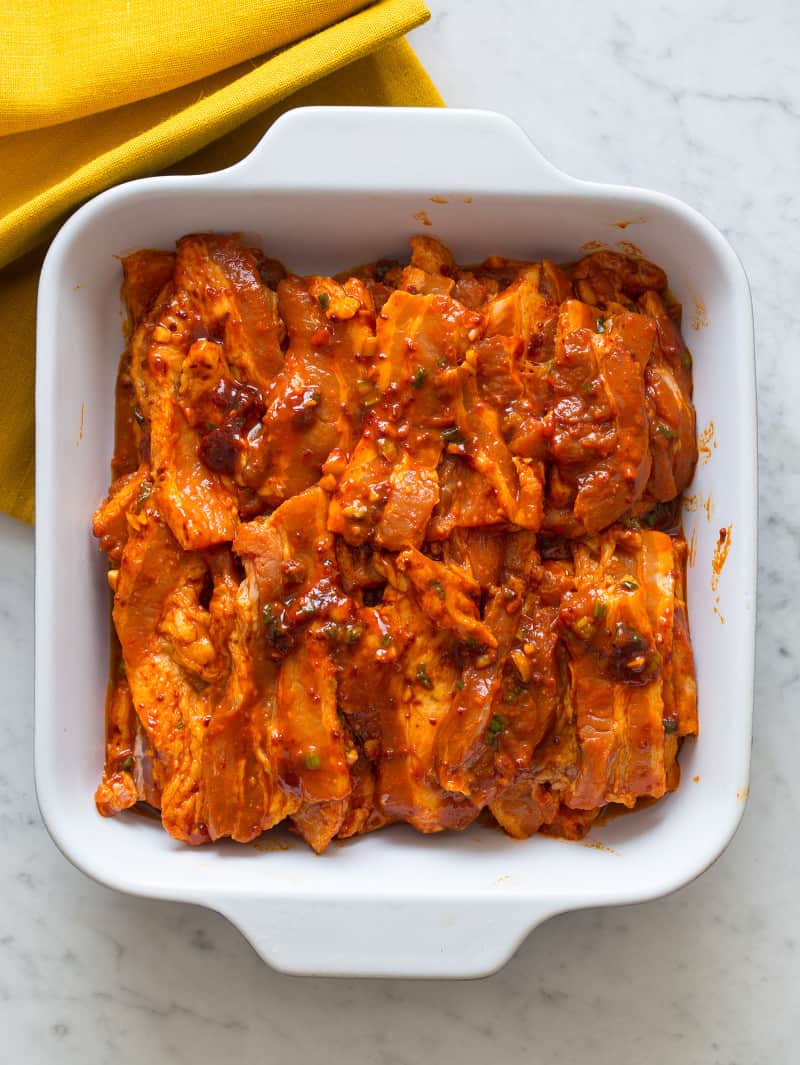 Korean style marinated spicy pork belly in a baking dish.