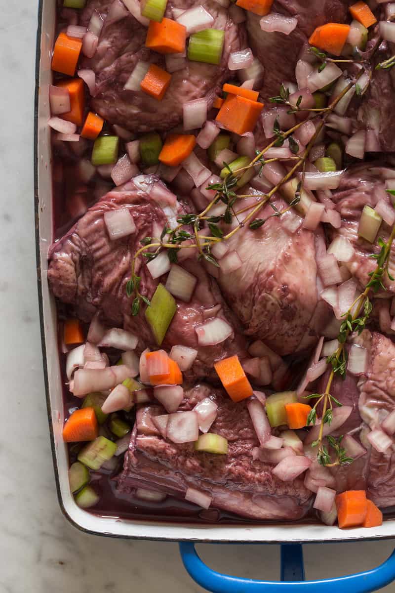 A close up of a pan of marinading chicken and vegetables.