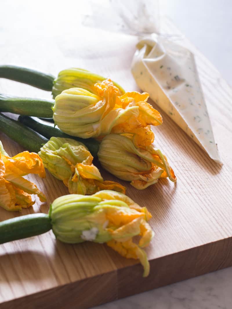 A close up of squash blossoms and filling in a piping bag.