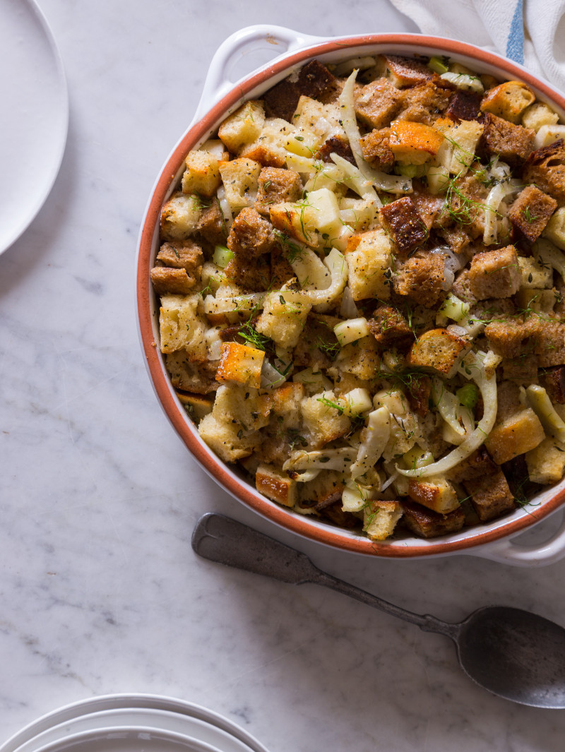 A bowl of apple and fennel stuffing with a spoon.