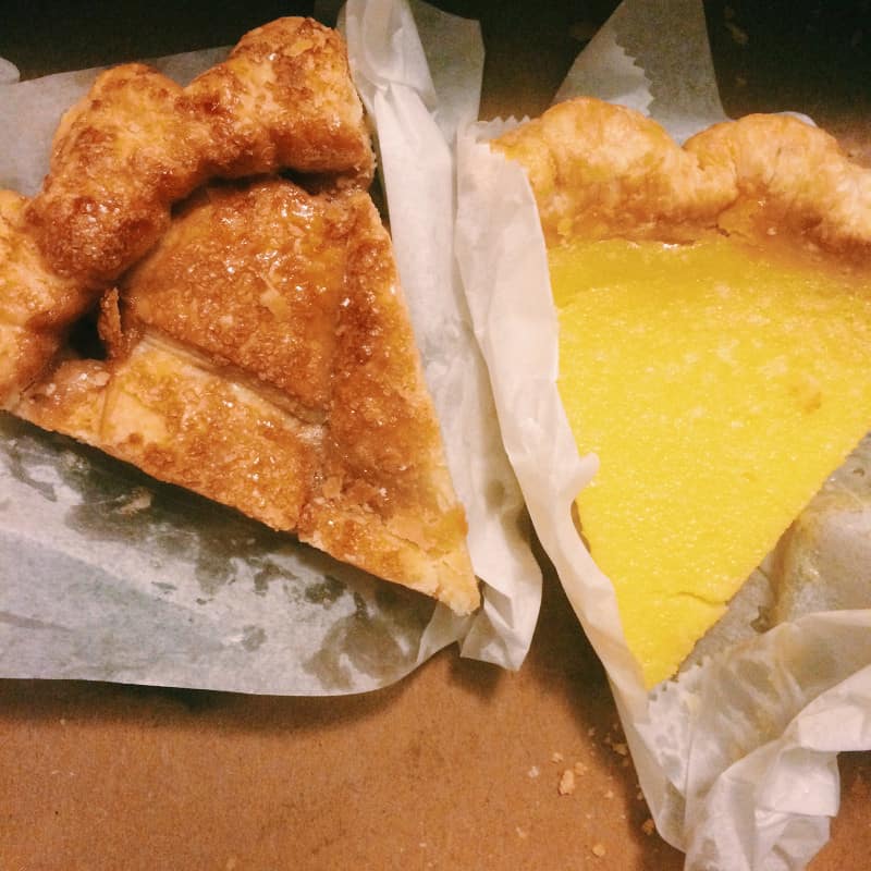 A close up of slices of two different types of pie.