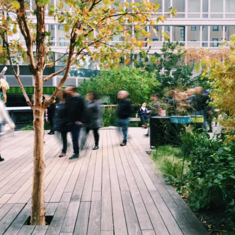 A group of people walking on a sidewalk.