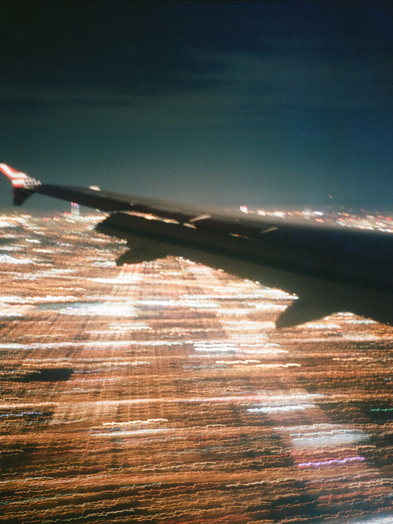 Beautiful view of the wing of an airplane and light below from inside the cabin.