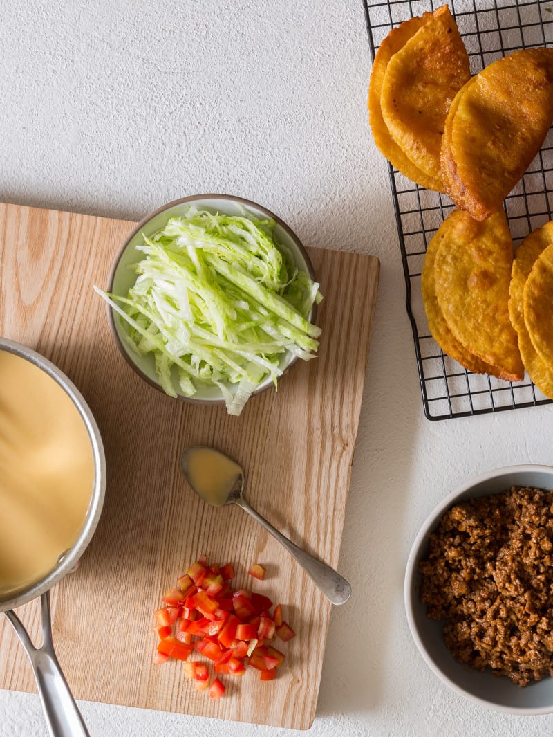 Ingredients to assemble crunchy ground beef and cheesy tacos.