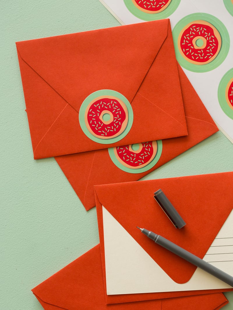 Doughnut printable food gift tags on red envelopes with a pen.