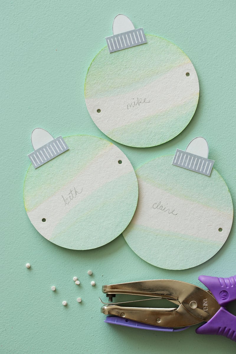 Assembled dip dye ornament gift tags with a hole punch and holes punched into sides.