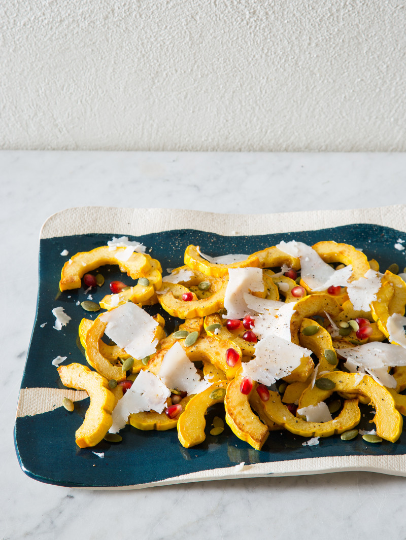A turquoise and white platter of honey roasted delicata squash.