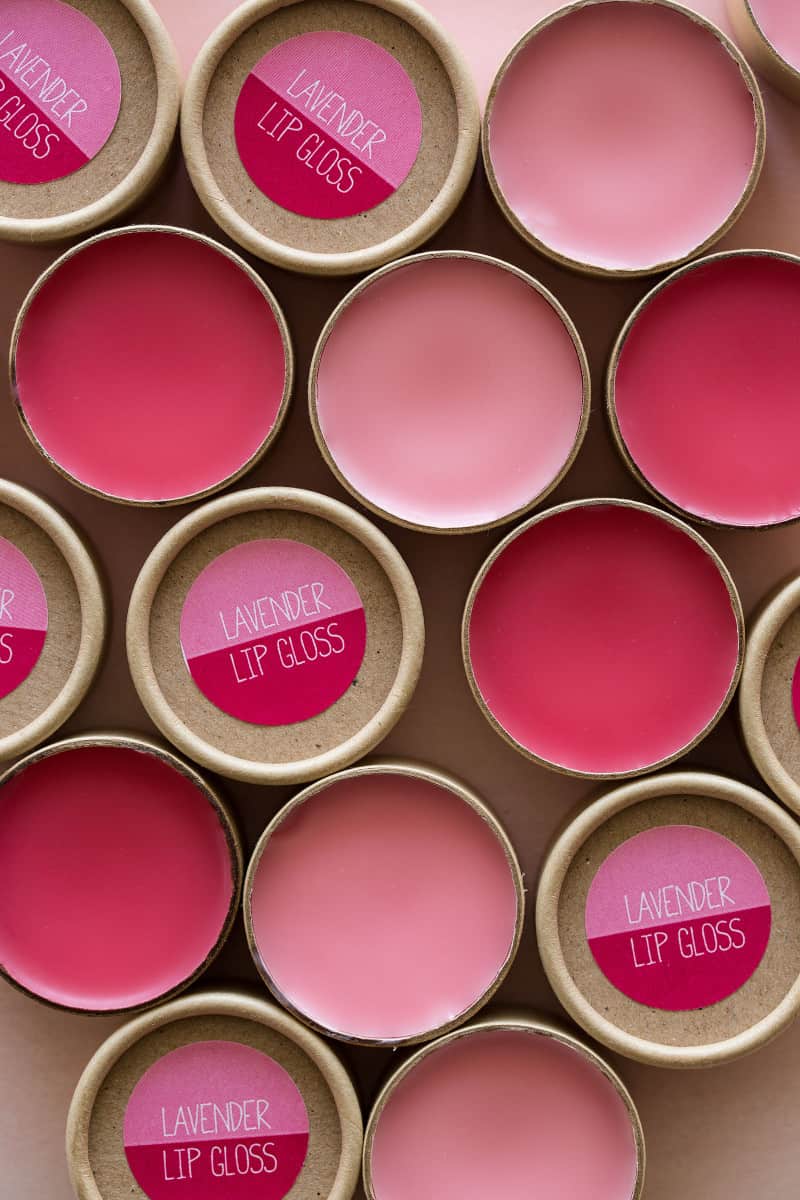 A close up of pink lavender lip gloss in containers and labeled.