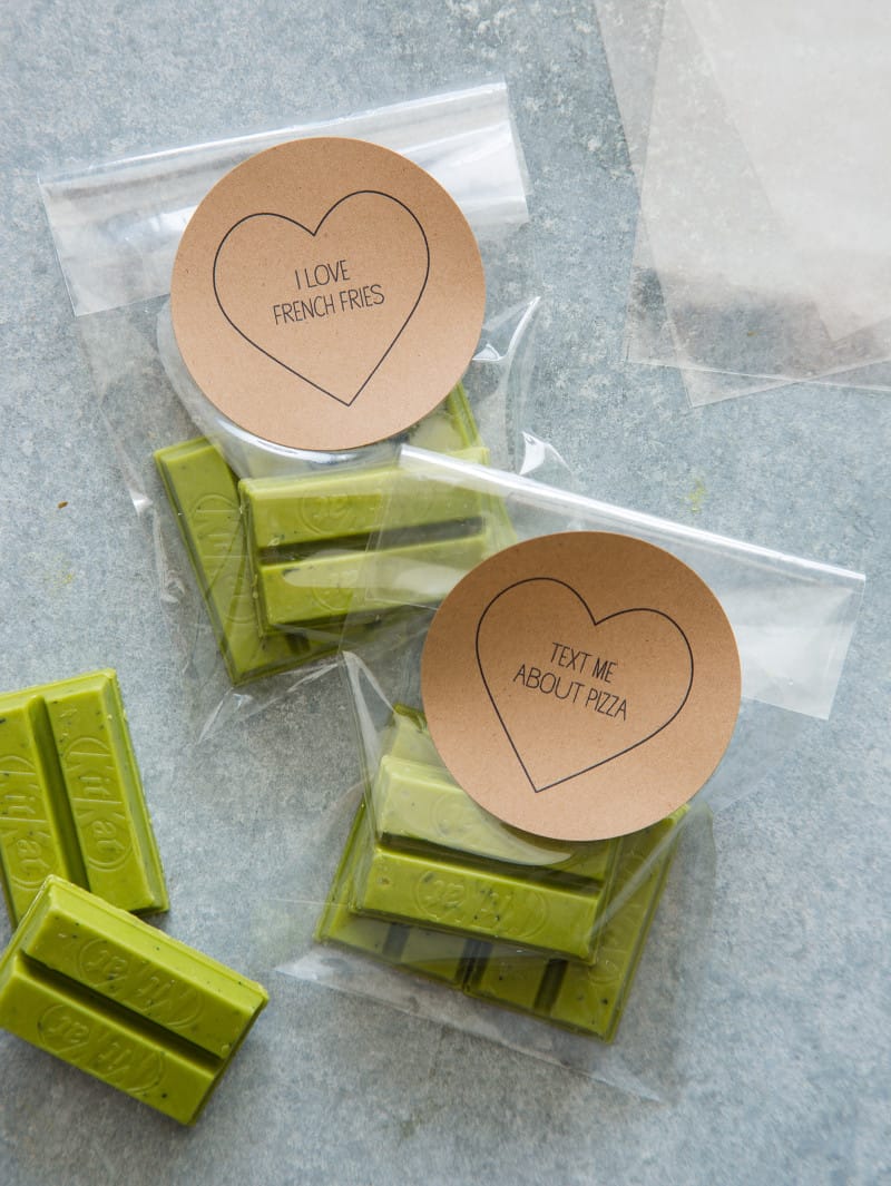 Valentine\'s conversation heart labels on clear bags of green tea Kit Kat bars.