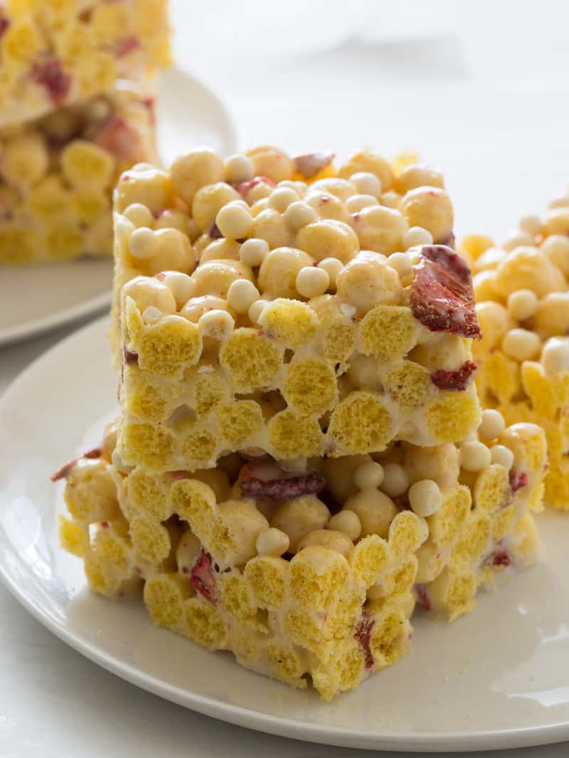 A close up of stacked freeze dried strawberry and white chocolate crispy balls Kix cereal treats.