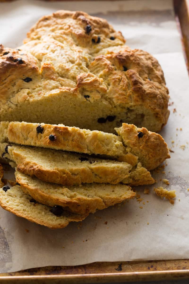 A close up of a sliced loaf of Irish soda bread with dried blueberries.