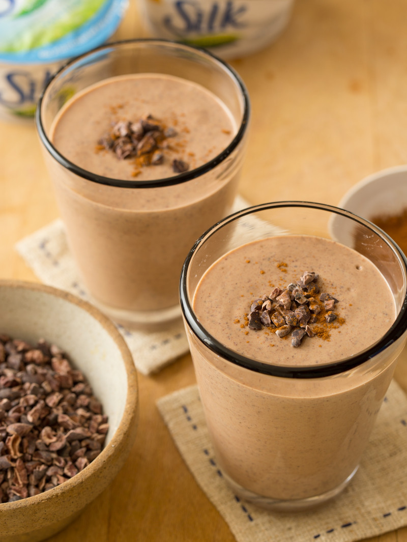 A close up of chocolate peanut butter and cinnamon smoothies in glasses with garnish.