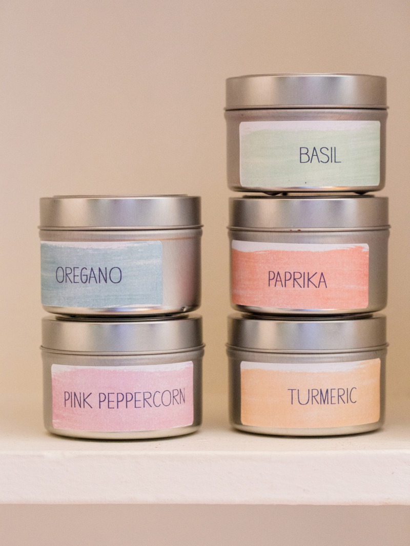 A close up of stacked printed spice labeled containers.