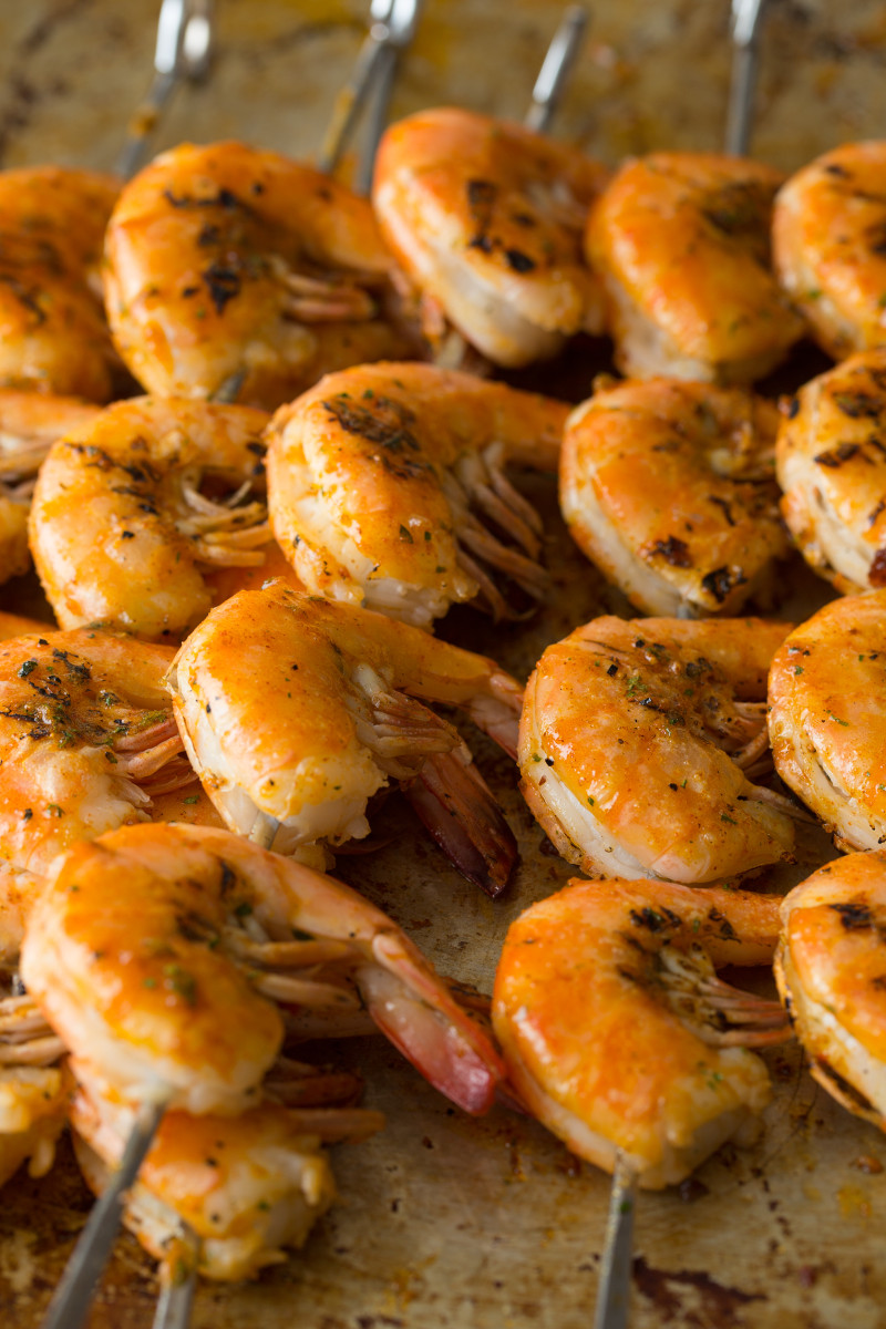 A close up of grilled peel and eat shrimp all lined up.