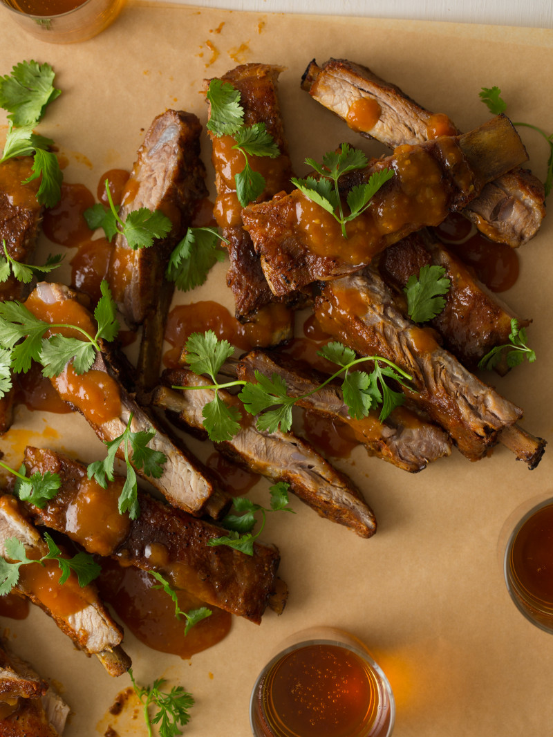 Spare ribs drizzled with mango habanero sauce with cilantro on top.