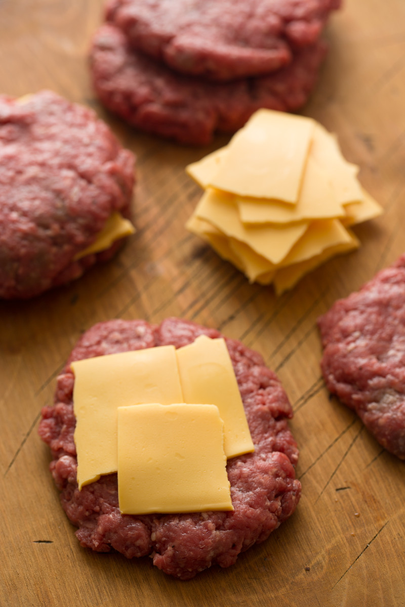 A close up of juicy lucy burger patties with cheese for the stuffing.