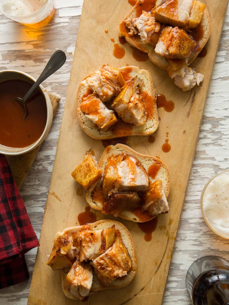 Crispy grilled pork belly with sweet and tangy vinegar BBQ sauce on bread.