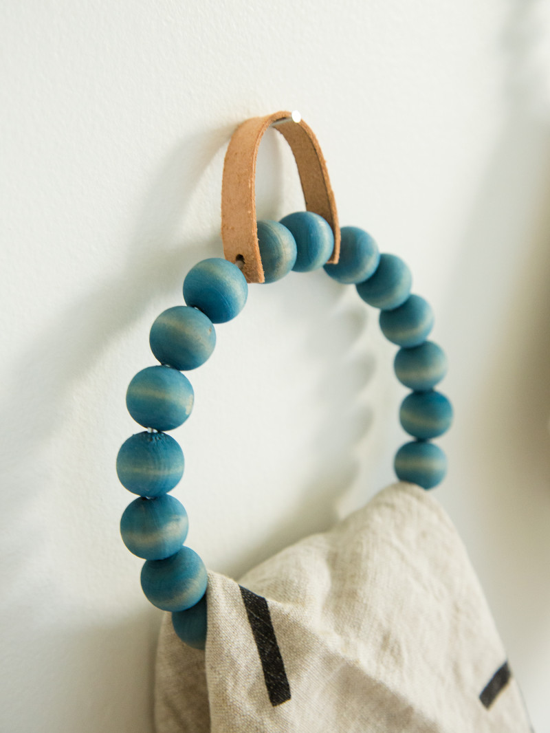 A close up of a DIY beaded towel ring with a towel hanging on it.