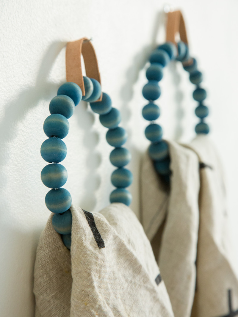 A close up of DIY beaded towel ring with towels hanging on them.