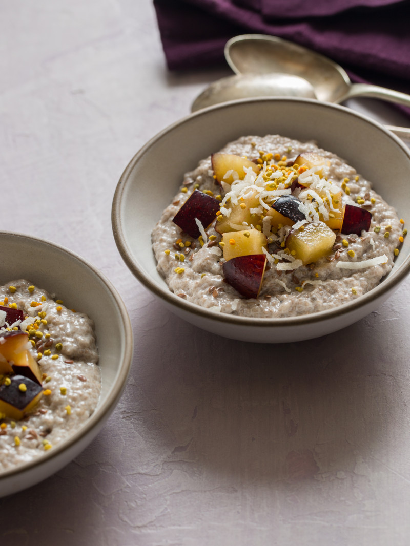 A close up of chia seed pudding topped with fruit and shredded coconut in a bowl.