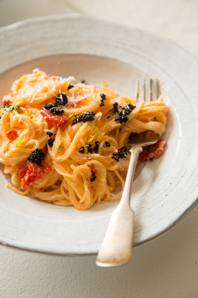 A bowl of capellini with a smoked salmon cream sauce twirled on a fork.
