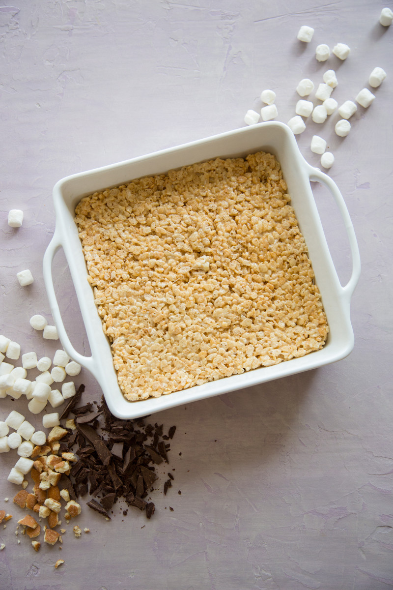 A white baking pan of rice krispies treats layer for s\'mores rice krispies treats.