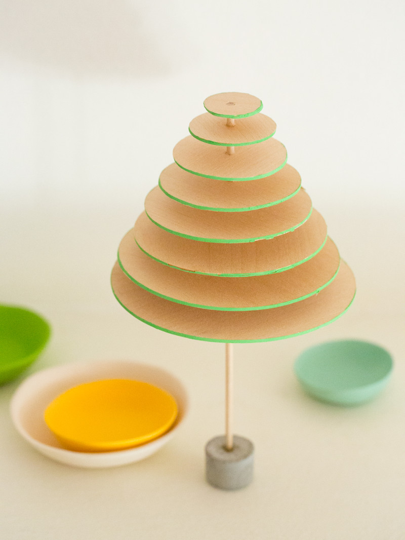 A close up of DIY modern mini balsa wood Christmas tree with small bowls below.