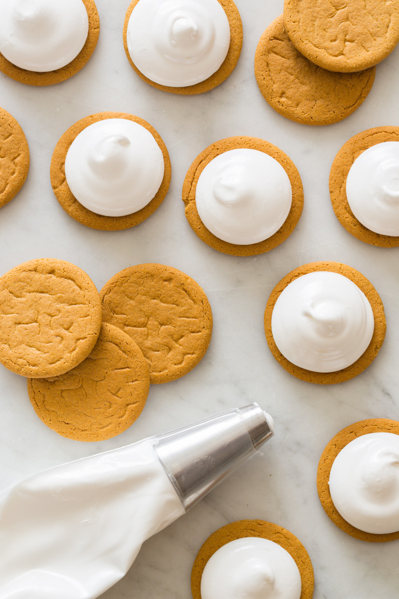 Process shot with gingersnap cookies, marshmallow, and a piping bag of marshmallow.