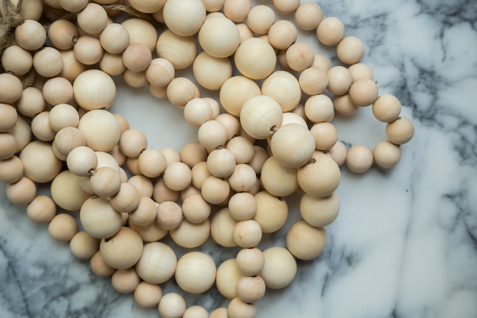 Strings of natural wood beads in preparation to dye. 