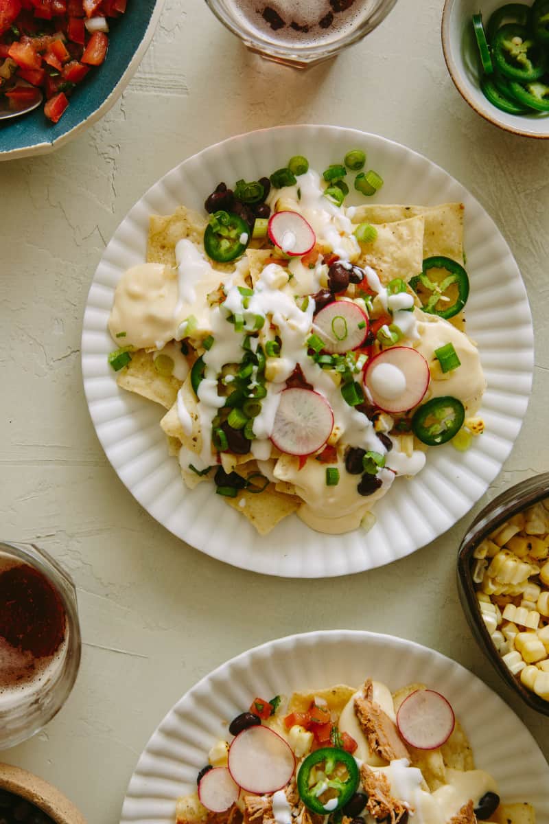 A plate of nachos made from DIY nacho bar with queso sauce.