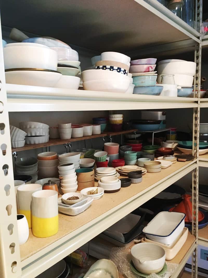 Shelves of different sized and colored bowls and ramekins.